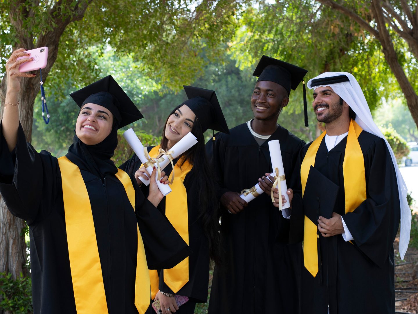 Graduates in gowns taking a photo together