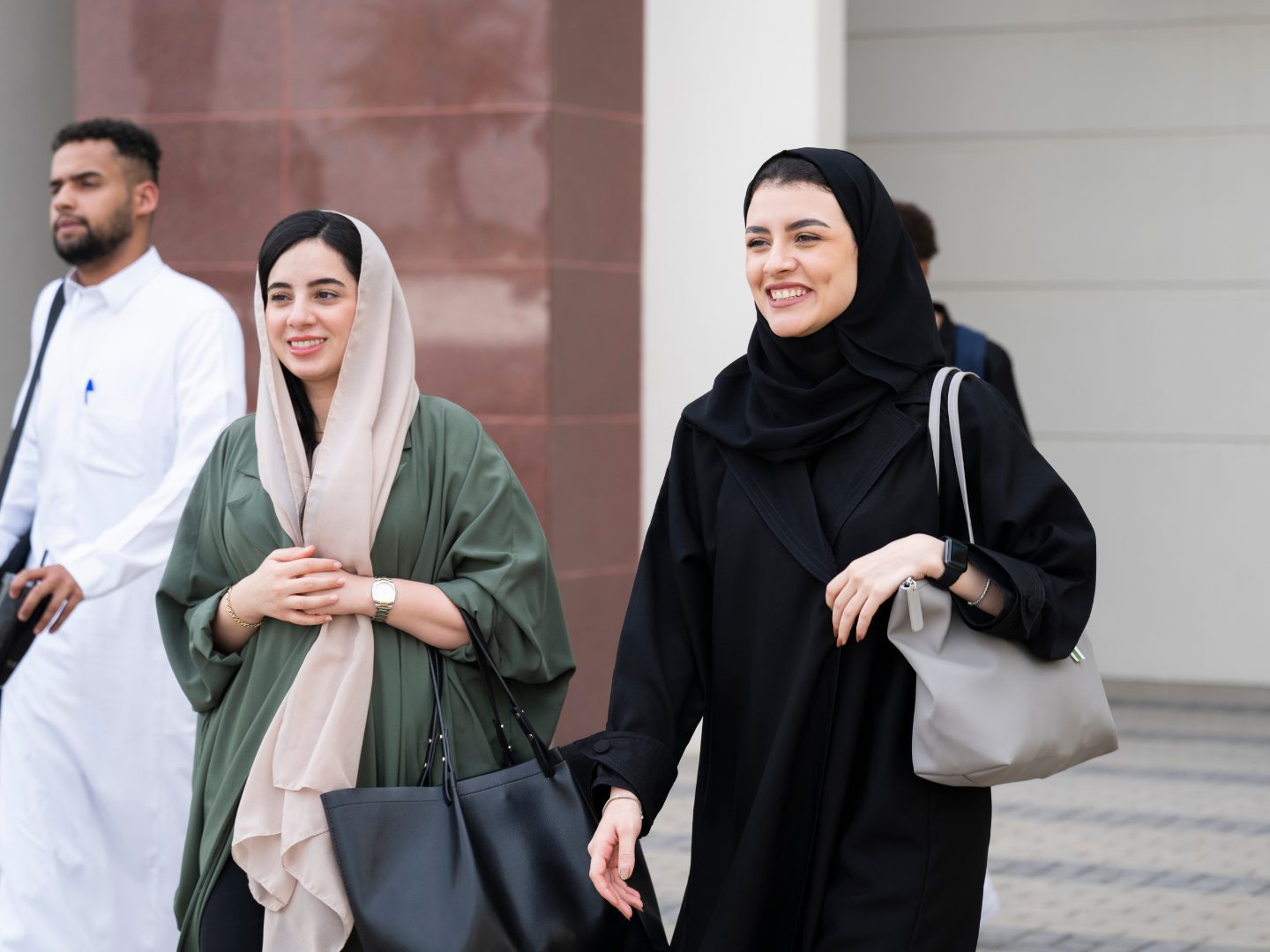 Three students walking across campus together